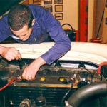 Mechanic performing car battery check-up