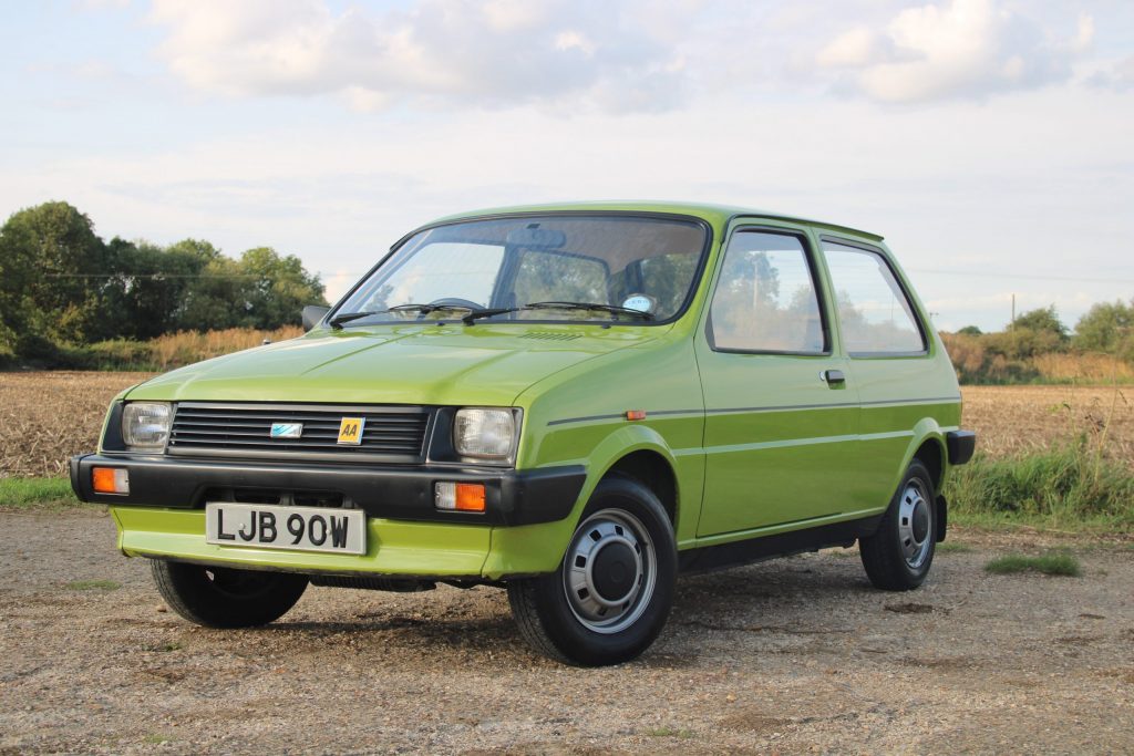 Front view of parked up green Austin Metro in a field