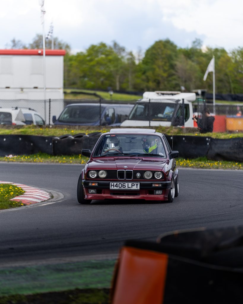 Red BMW E30 at racing circuit