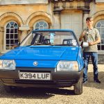 Owner standing next to Skoda Favorit parked on gravel in front of castle