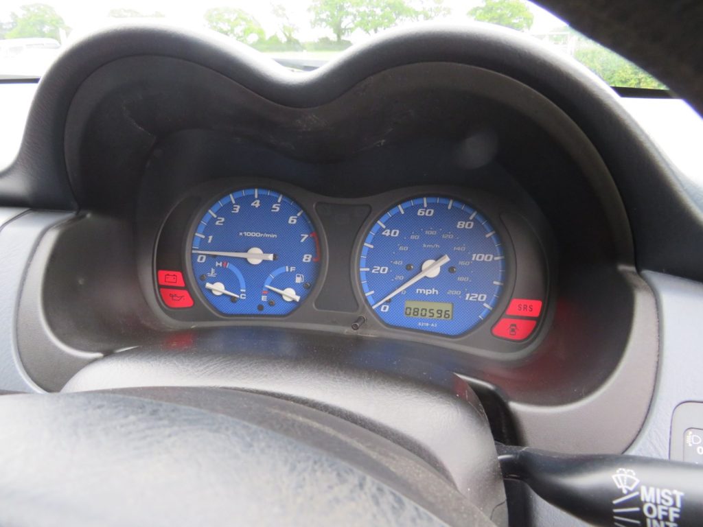 Blue analogue dials on grey dashboard