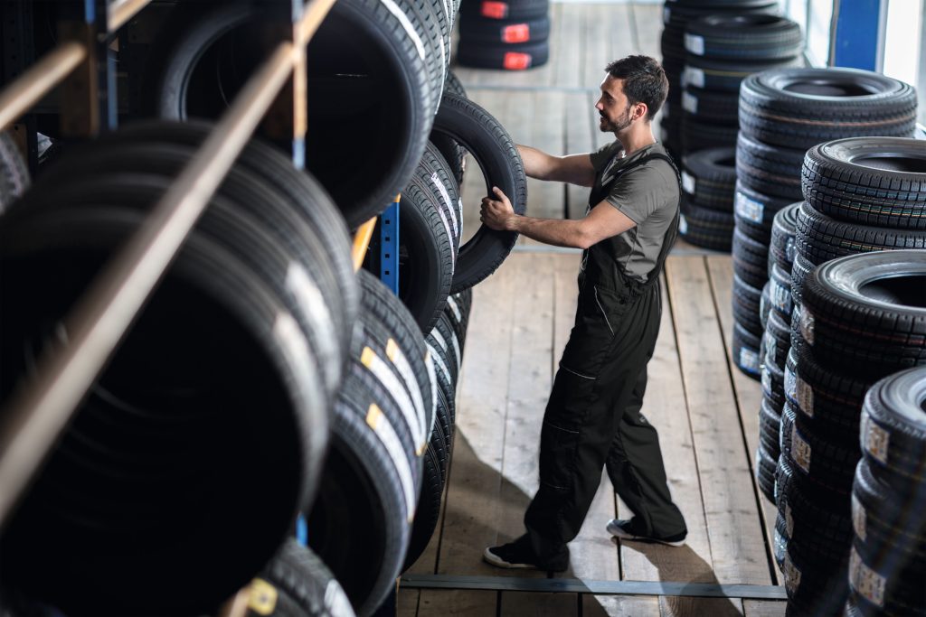 Man moving car tyres in tyre shop