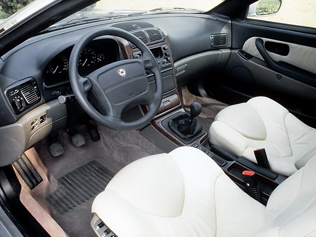 Interior cabin of car with white leather front seats