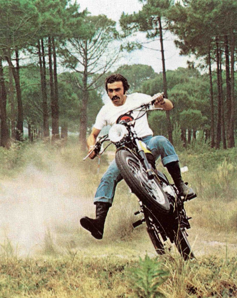 Man riding classic motorbike with front wheel suspended