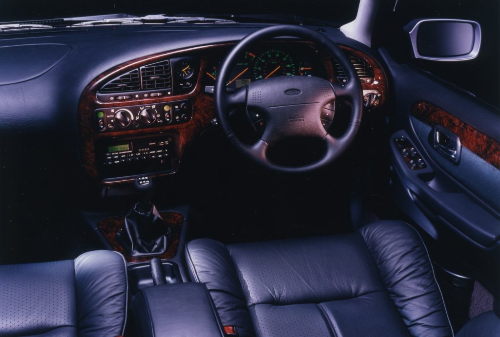 Interior cabin, black leather front seats and steering wheel of car
