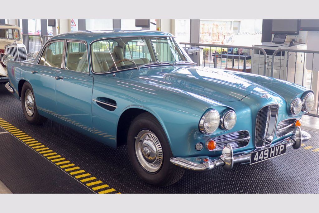 Front view of a metallic light blue car parked on rubber matting