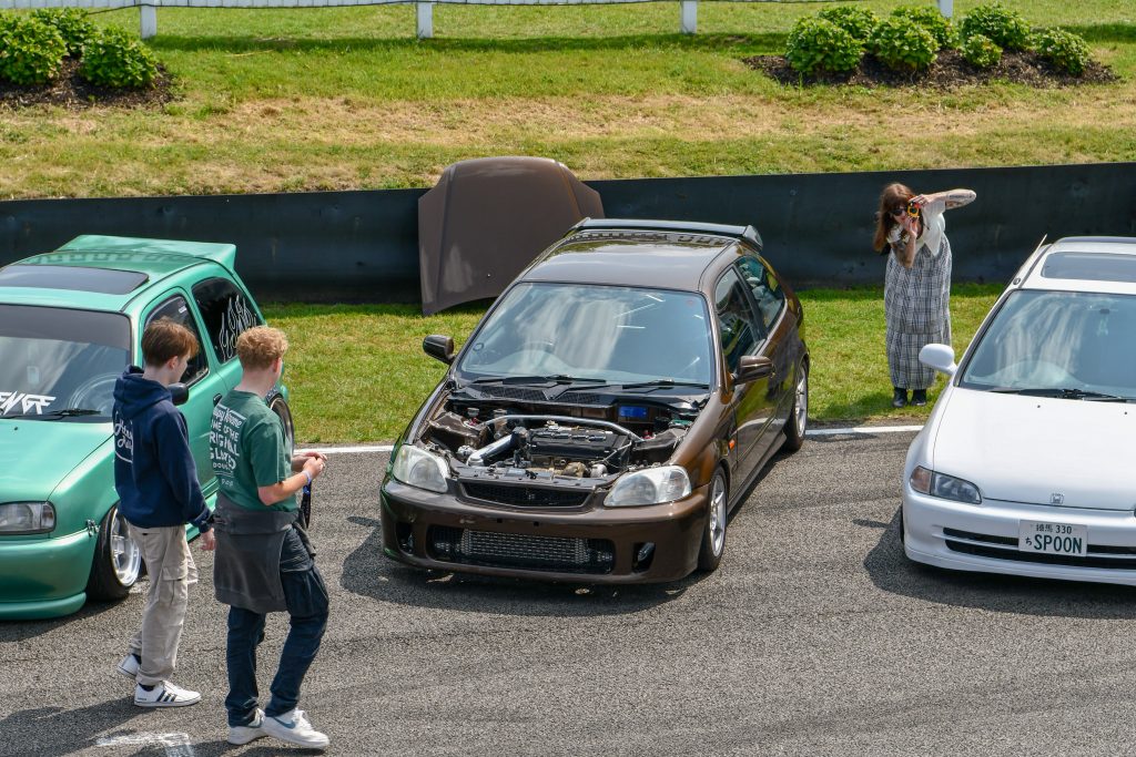 Three cars parked in a row on tarmac in front of grass verge