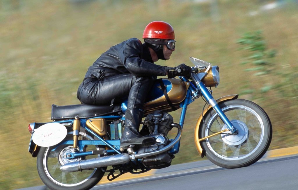 Man riding blue and gold motorbike at speed