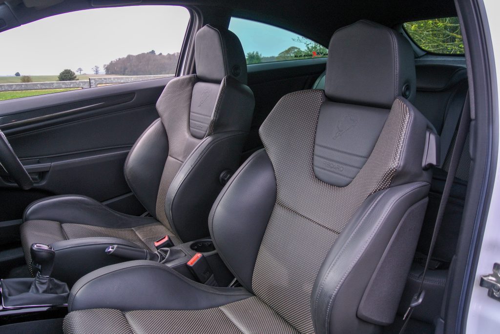 Two black leather front car seats and front window