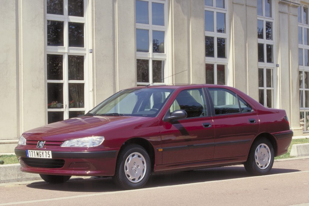 Maroon Peugeot 406 SR parked in front of a light stone building