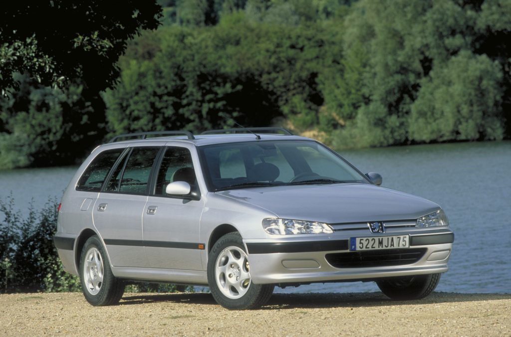 Silver Peugeot 406 estate parked on gravel in front of a lake