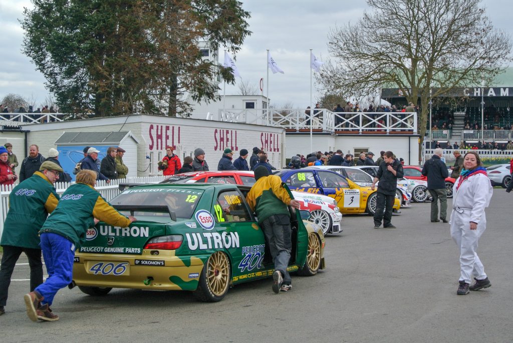 Green and gold Peugeot 406 BTCC being pushed in a pit lane