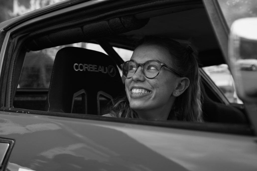 Close up of a woman smiling inside a car with the window open