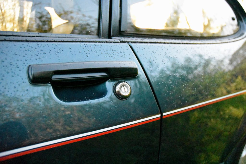 Close up of the door handle and lock of a green car