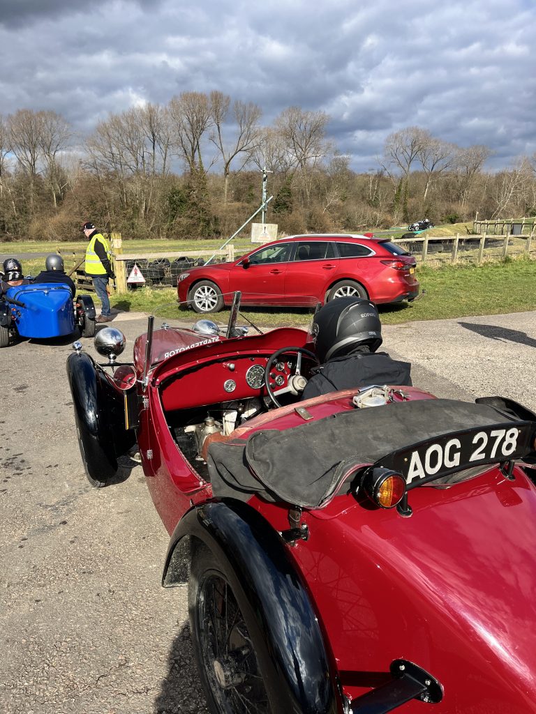 Three cars parked in a car park on a grey cloudy day