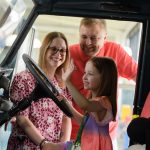 A family looking inside a car at the British Motor Museum