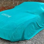 Parked car with a tailored protection cover on