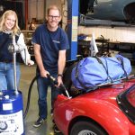 man and girl working on a gar in a garage