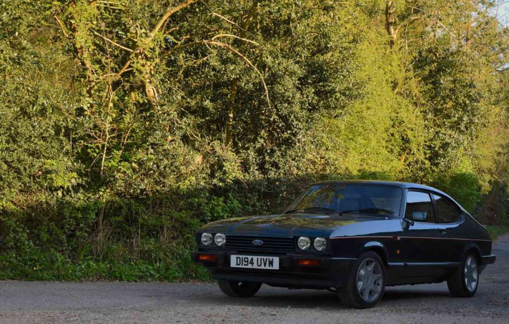 Green Ford Capri 280 parked up in front of trees