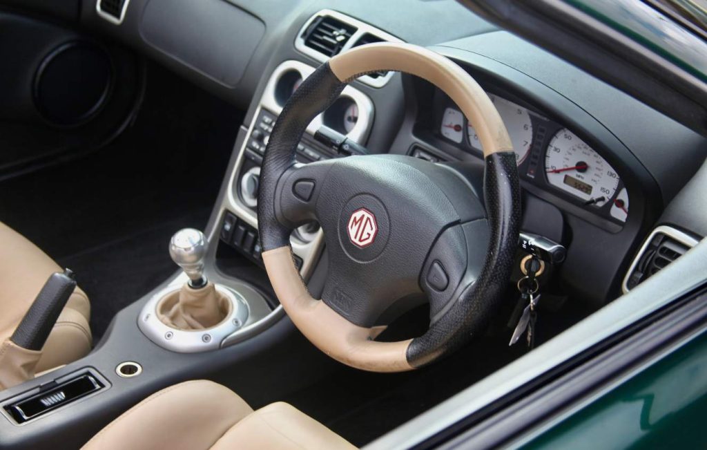 Close up of cream and black leather car steering wheel