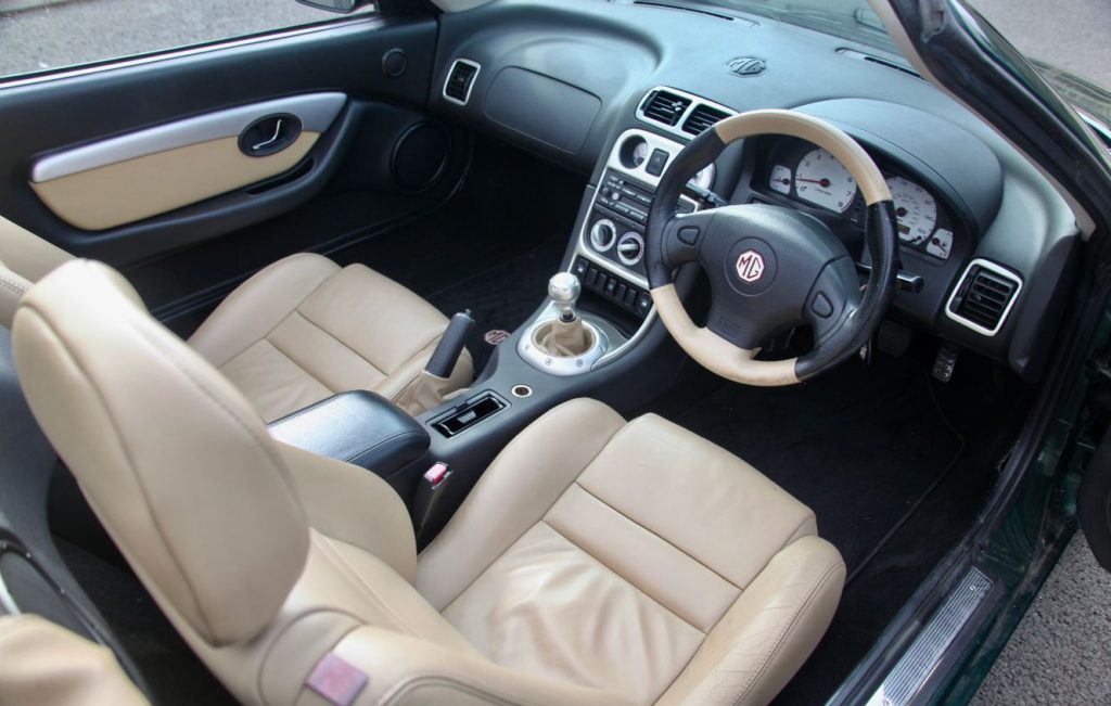Open car door showing cream leather interior cabin