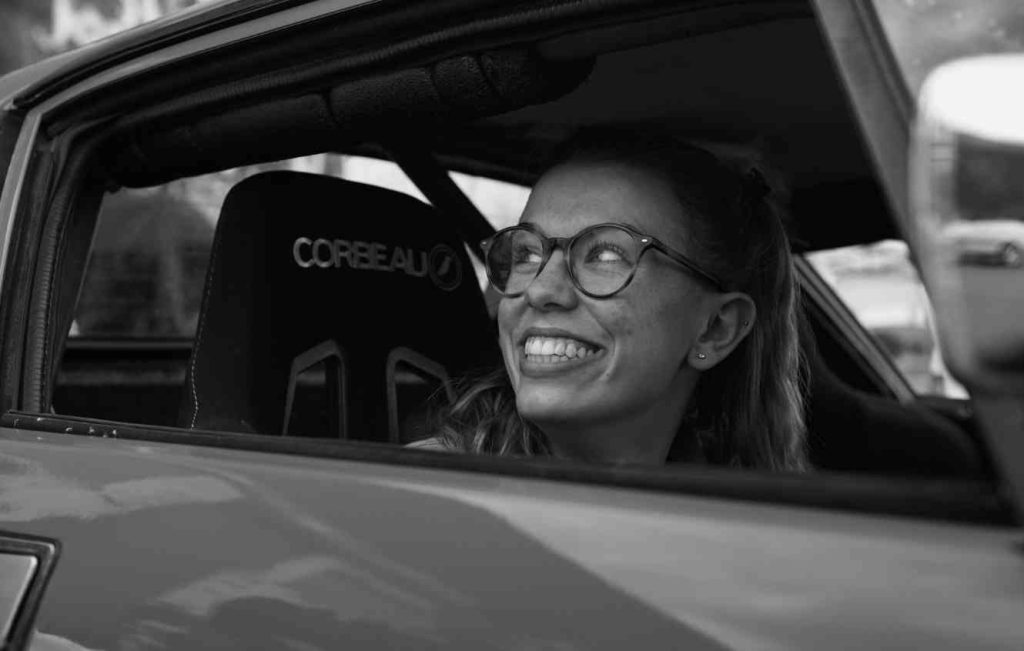 Close up of a woman smiling inside a car with the window open