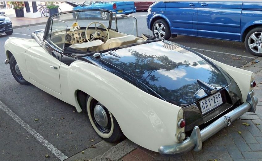 Black and white convertible classic car reverse parked in a car park