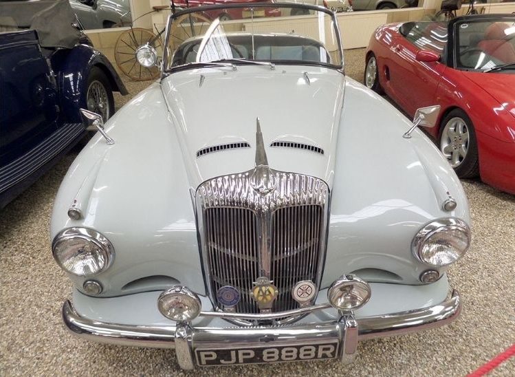 Blue Daimler parked on gravel