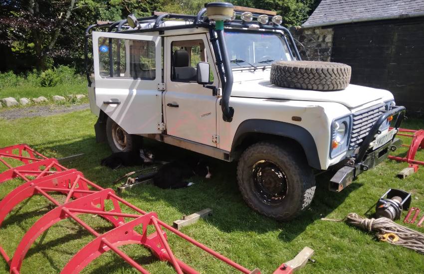 White Landrover Defender parked on grass