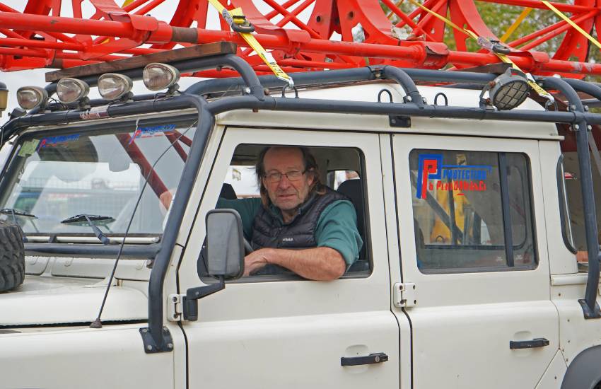Man sitting in the driver's seat of a white car looking out the window