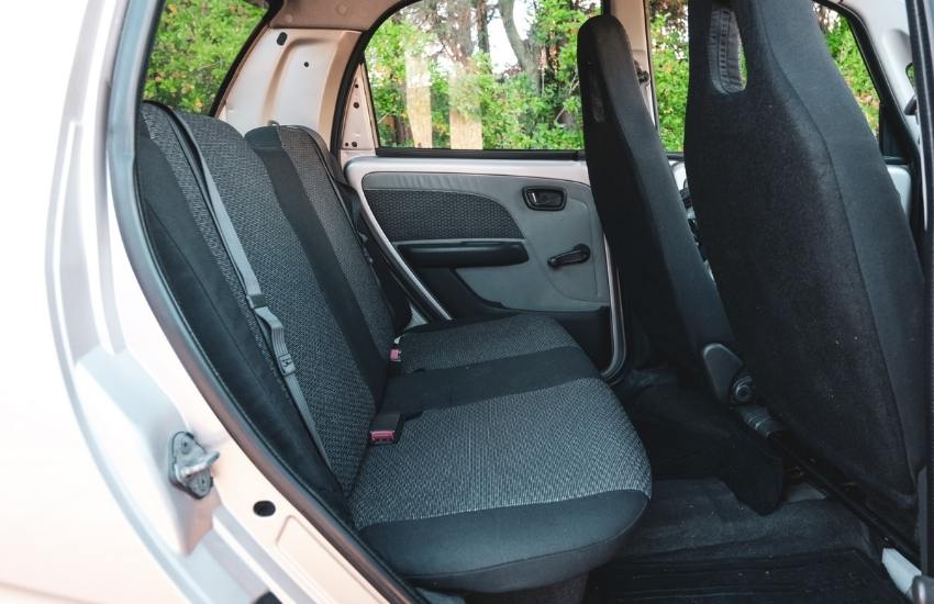 Rear door of a car open showing the two rear fabric covered seats