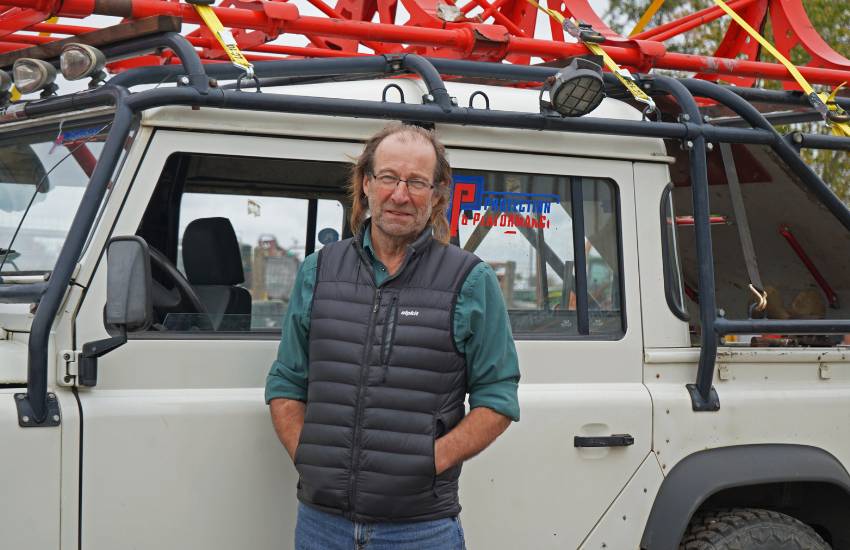 Man standing in front of a white car smiling
