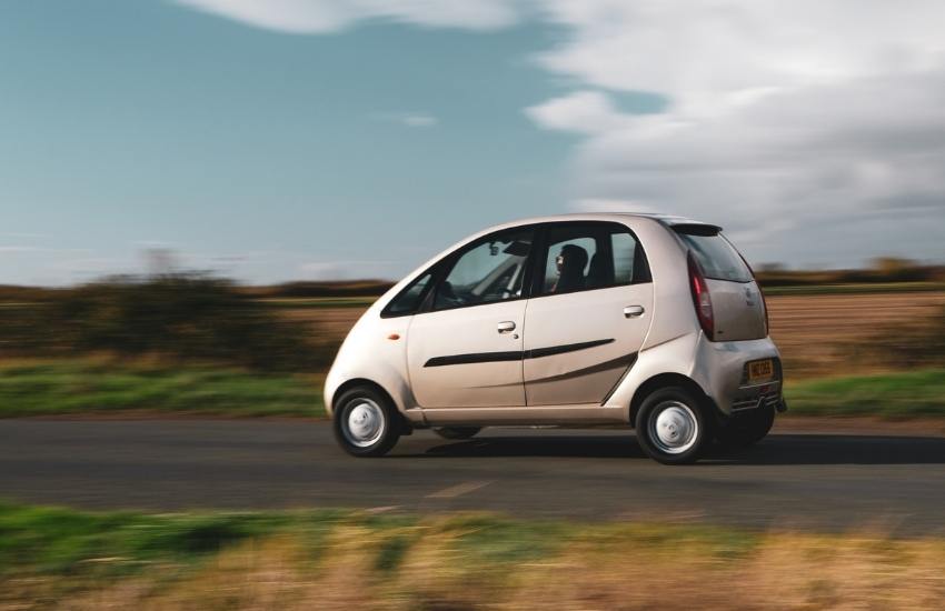 Tata Nano driving along a country lane with fields in the background