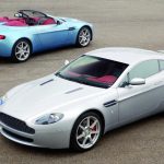 Two 00s exotic Aston Martin Vantages parked on a road