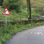 Right hand bend of a road through green fields
