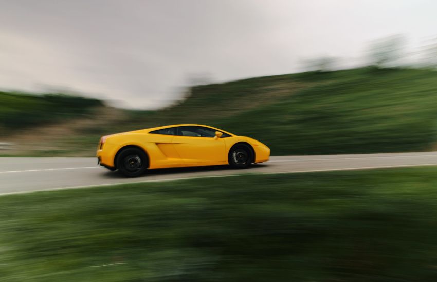 Side view of a yellow Lamborghini Gallardo V10 in motion