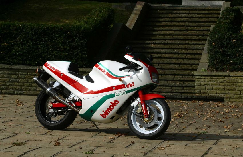 White, red and green classic motorbike parked up