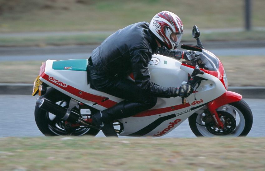 Man riding a classic motorbike around a bend at speed