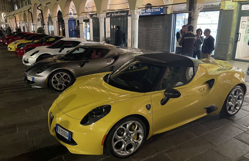 Six Alfa Romeo 4C cars parked in a row on a street