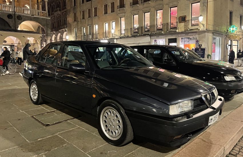 Black Alfa Romeo 155 parked on a street at night time