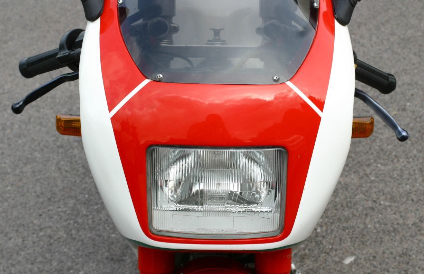 Front headlight of a red and white classic motorbike