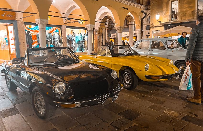 Two classic Alfa Romeo Spider convertibles parked up during night time