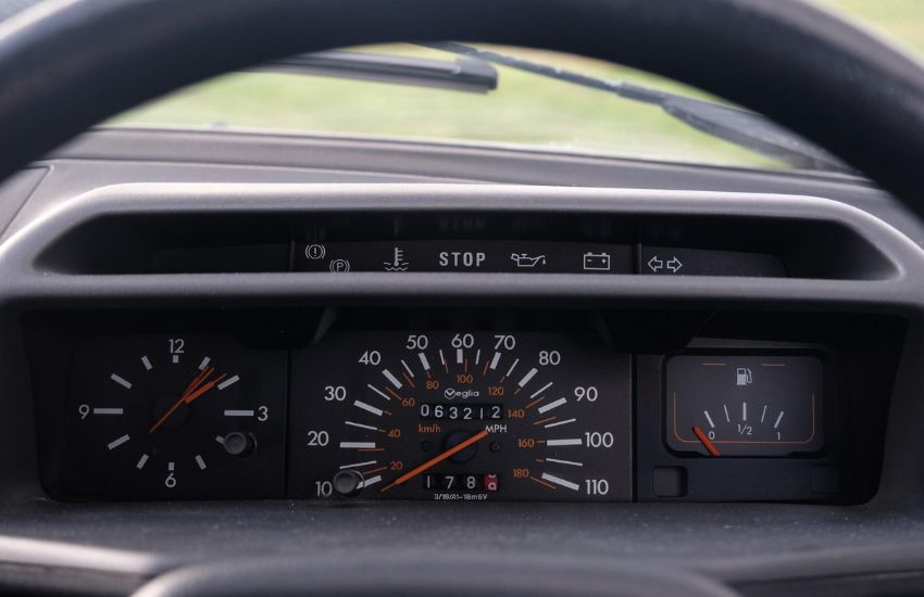 Close up of a car's dashboard showing speedometer and clock