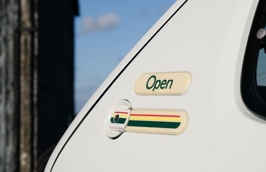 Close up of badge and fuel cap of a white classic car