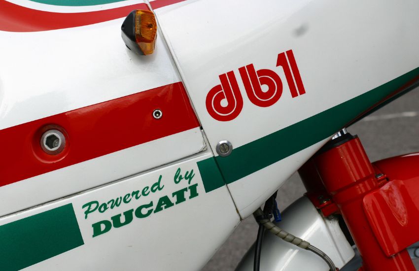 Close up of red and green decals on a white classic motorbike