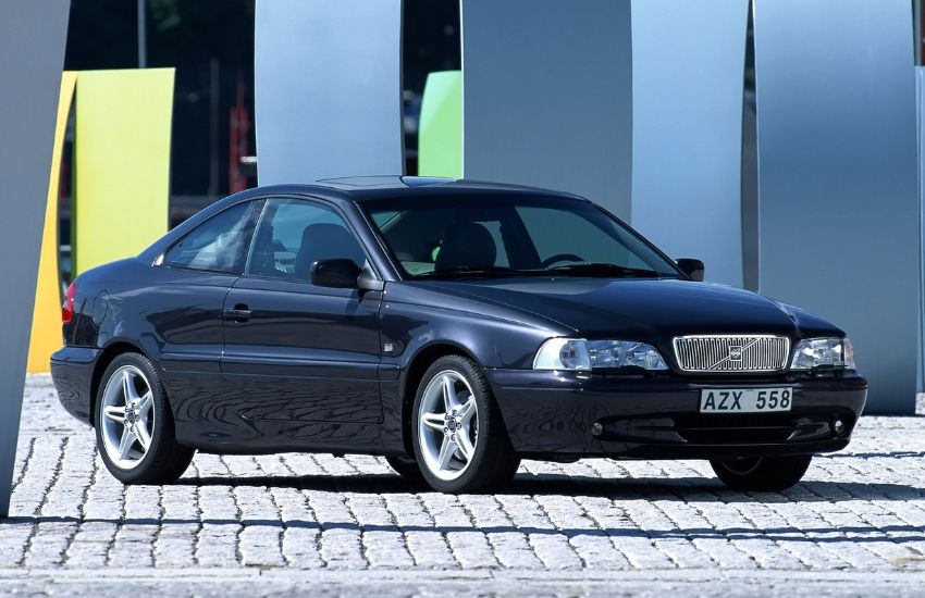Side view of a black Volvo C70 parked on a block paved road
