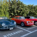 Several classic cars, including two Porsche 356 models parked in a row
