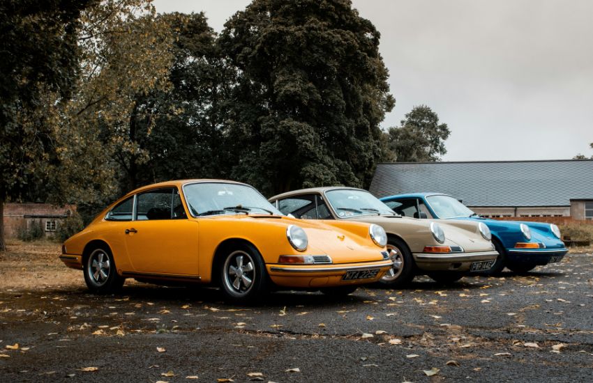 Three classic Porsche cars parked side by side, illustrating multi-car insurance coverage for multiple vehicles.