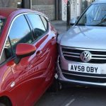 Silver car colliding into the rear nearside of a red car
