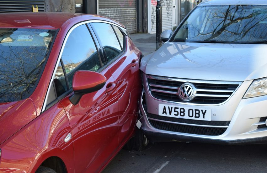 Silver car colliding into the rear nearside of a red car